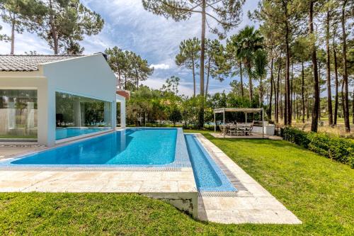 a swimming pool in the backyard of a house at Aroeira Modern Grand Villa With Pool by Homing in Aroeira