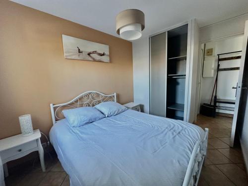 une chambre avec un lit avec une couette bleue dans l'établissement Loubapa, appartement en rez-de-jardin, à Courseulles-sur-Mer
