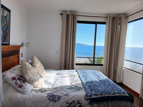 a bedroom with a bed with a view of the ocean at Department la Serena Beach in La Serena