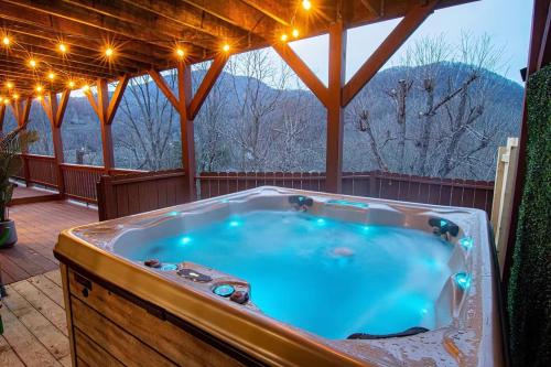 Un gran jacuzzi en una terraza con luces. en Mtn Views, HotTub, Sauna, Outdoor Theater, FirePit, en Waynesville