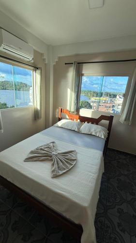a bedroom with a large bed with a large window at Hotel Beira Rio in Oiapoque