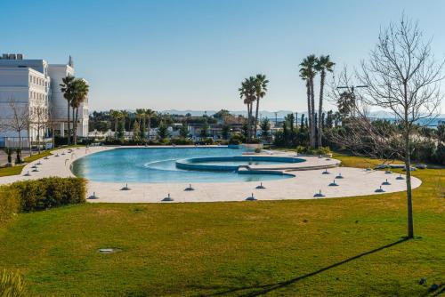 a large swimming pool with birds in a park at Talea Holiday Apartments 1 in Lezhë
