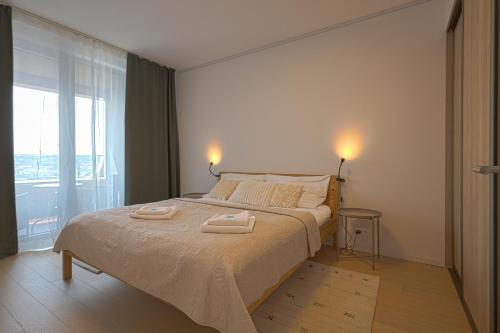 a bedroom with a bed with two towels on it at SKAU Sky Park Green by Zaha Hadid 22 floor 1 Tower Panoramic View Free Parking in Bratislava