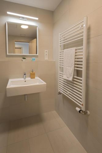 a bathroom with a sink and a mirror at SKAU Sky Park Green by Zaha Hadid 22 floor 1 Tower Panoramic View Free Parking in Bratislava
