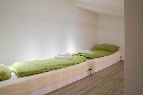 a bedroom with two beds with green comforters at Appartementhaus Brunsholm in Esgrus
