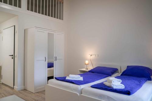 two beds in a room with blue sheets and towels at Appartementhaus Brunsholm in Esgrus