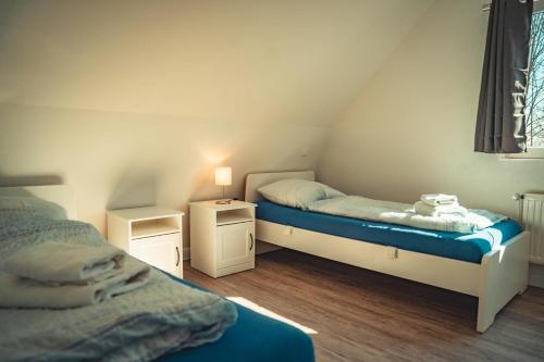 a bedroom with two twin beds and a window at Appartementhaus Brunsholm in Esgrus