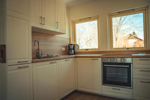 a kitchen with white cabinets and a window at Appartementhaus Brunsholm in Esgrus