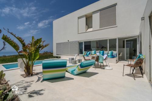 a patio with chairs and tables and a house at The Wild Ocean in Santa Cruz