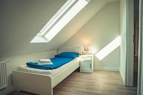 a bedroom with a bed with blue pillows and a window at Appartementhaus Brunsholm in Esgrus