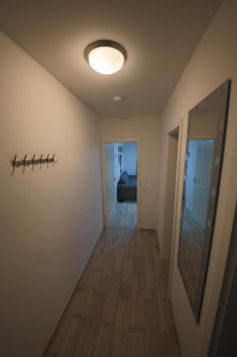a hallway with a ceiling light and a mirror at Appartementhaus Schleiblick in Kappeln