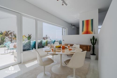 a white dining room with a table and chairs at The Wild Ocean in Santa Cruz