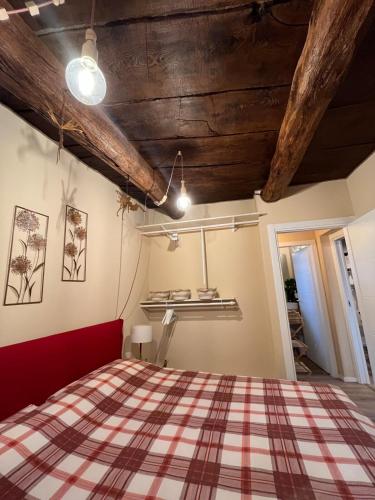 a bedroom with a red bed in a room with wooden ceilings at Luna Home in Arona