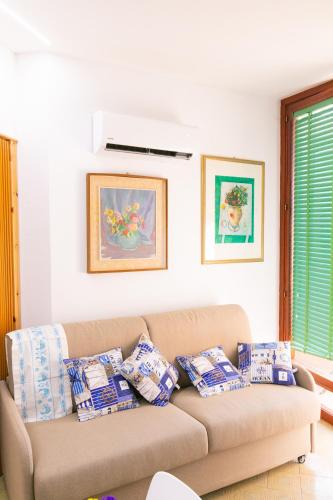 a living room with a brown couch with pillows at Teulada cozy flat with pool and beach access in Teulada