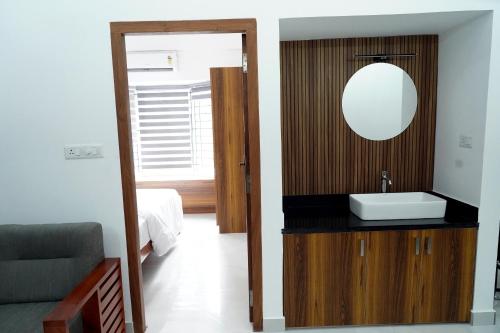 a bathroom with a sink and a mirror at Enhance Lifestyle Service Apartments in Thamarassery