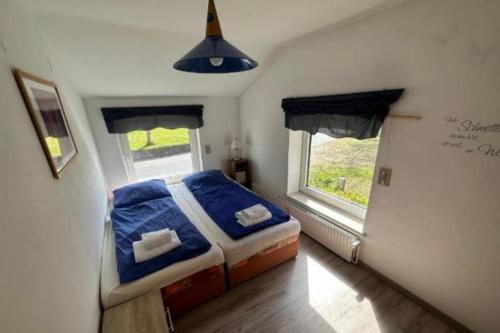 a bedroom with a bed with blue sheets and a window at Monteurzimmer an der Schlei in Rabenkirchen-Faulück