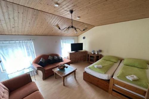 a living room with a bed and a couch at Monteurzimmer an der Schlei in Rabenkirchen-Faulück