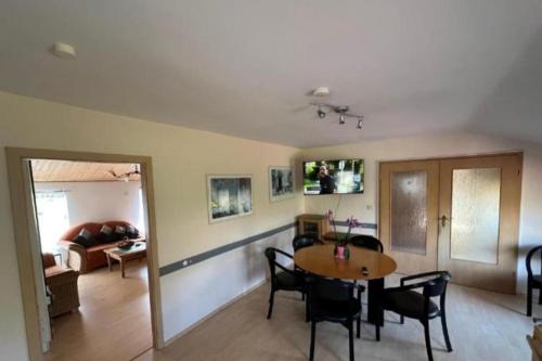 a dining room and living room with a table and chairs at Monteurzimmer an der Schlei in Rabenkirchen-Faulück
