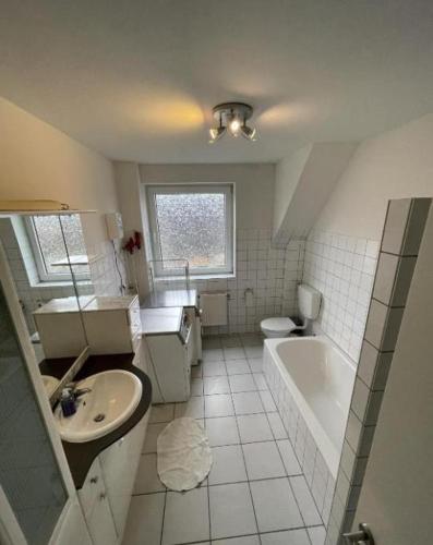 a bathroom with a sink and a tub and a toilet at Monteurzimmer an der Schlei in Rabenkirchen-Faulück