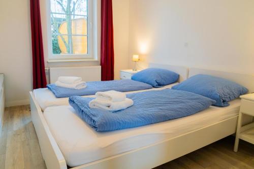two beds with towels on top of them in a room at Appartementhaus Schleiblick in Kappeln