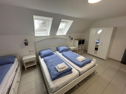 a bedroom with two beds with blue pillows at Appartementhaus Schleiblick in Kappeln
