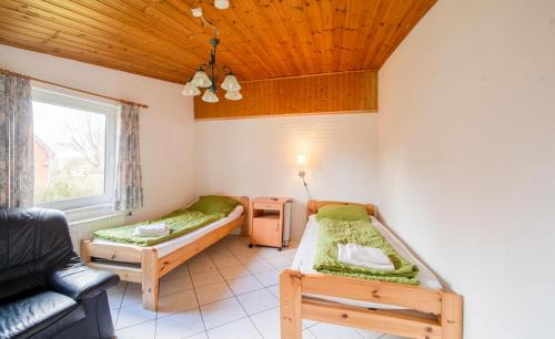 a room with two beds and a couch and a window at Monteurzimmer bei Kappeln in Rabenkirchen-Faulück