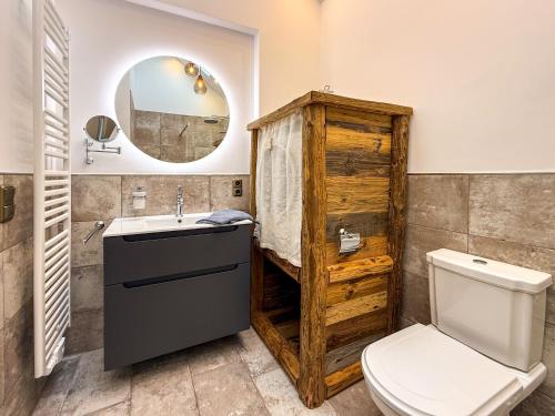 Un baño con inodoro, lavabo y espejo. en Dat Fleetenkiekerhus 2, en Hage