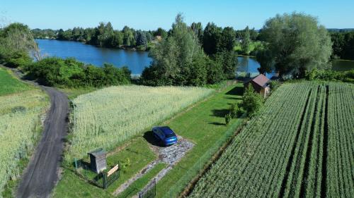 a blue car parked in a field next to a road at Ku Jezioru in Pawłowice