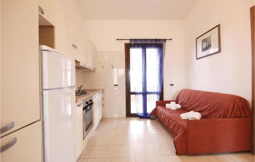 a living room with a red couch and a kitchen at Beautiful Apartment In Costa Rei -Ca- With Wifi in Monte Nai
