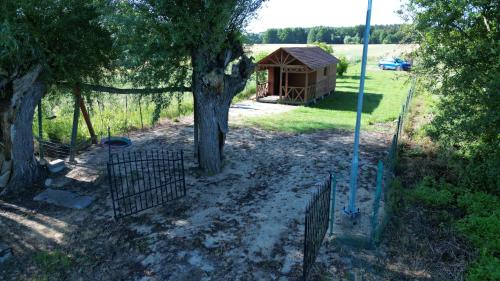 a gate in front of a tree and a smallshed at Ku Jezioru in Pawłowice