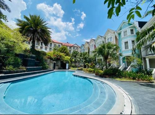 a swimming pool in a villa with palm trees and houses at Townhouse Mellow Yellow D#220 3storey 120sqm in Batangas City