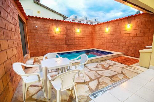 a patio with a table and chairs and a swimming pool at Piri House in Pirenópolis