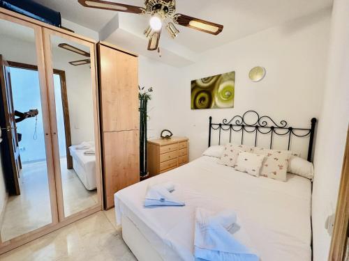 a bedroom with a white bed and a mirror at T252 - Atrium Beach 2 - 2004 Finestrat in Cala de Finestrat