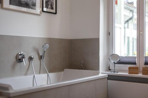 een badkamer met een wit bad en een raam bij App Osiria in Kühlungsborn