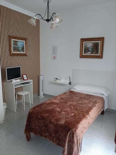 因赫尼奥Vivienda el Timón的一间卧室，配有一张床和一张带电脑的书桌