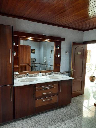 a bathroom with two sinks and a large mirror at Vivienda el Timón in Ingenio