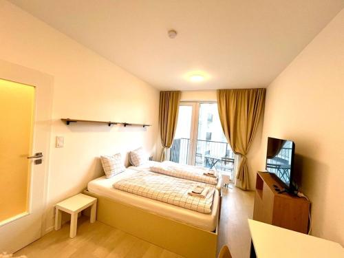 a hotel room with a bed and a television at Bella Apartments Brno in Brno