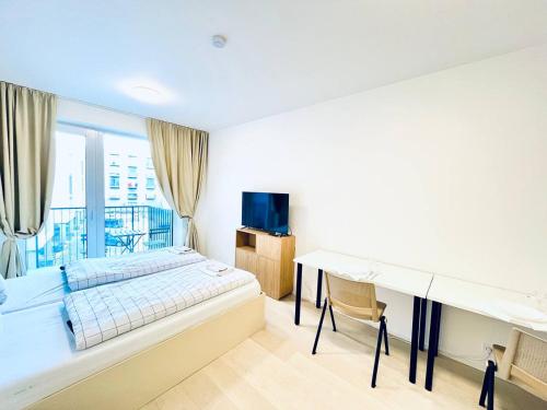 a bedroom with a bed and a desk and a television at Bella Apartments Brno in Brno