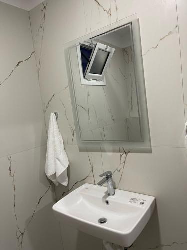 a white bathroom with a sink and a mirror at Aria Apartments in Borsh