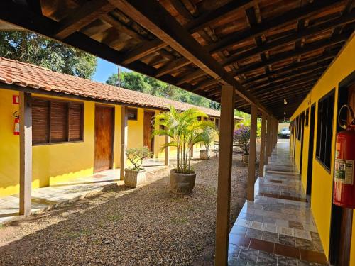 an outside view of a yellow building with a roof at Pousada Boa Vista in Brotas