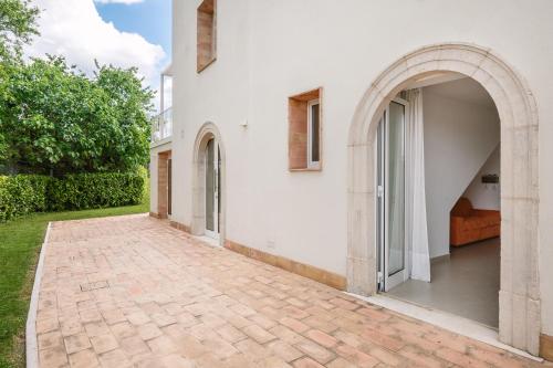 an entrance to a white building with an archway at Agriturismo Le Masciare in Paternopoli