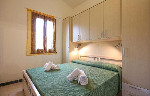 a bedroom with two towels on a green bed at Awesome Apartment In Costa Rei -Ca- With Wifi in Monte Nai