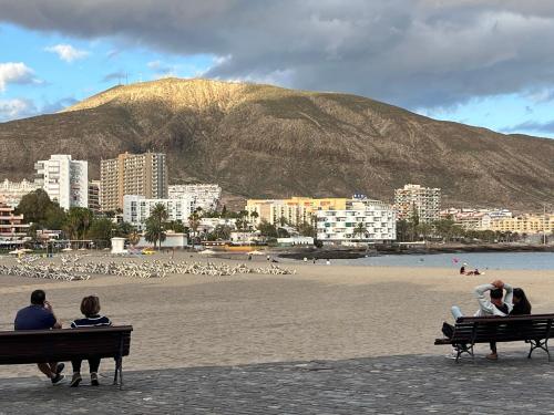een groep mensen op banken op het strand bij CORNELIAS HOME 5A playa in Los Cristianos