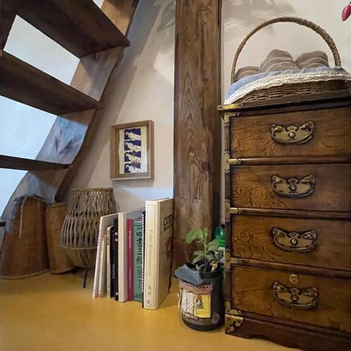 a room with a dresser and books on the floor at Alleyway 모퉁이 in Jeonju