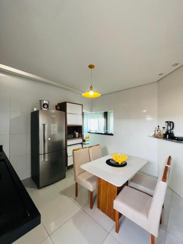 a kitchen and dining room with a table and a refrigerator at Apartamento panorâmico com 2 suítes 1 quarto in Petrolina