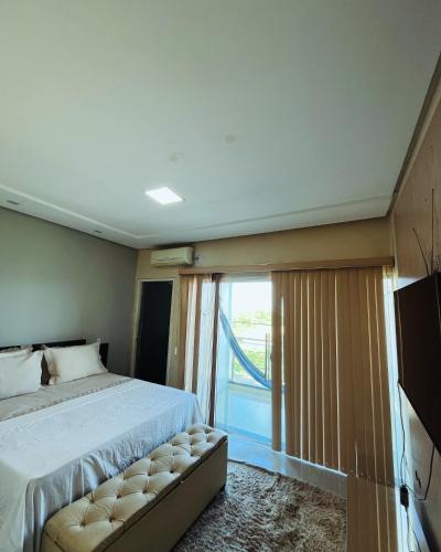 a bedroom with a bed and a large window at Apartamento panorâmico com 2 suítes 1 quarto in Petrolina