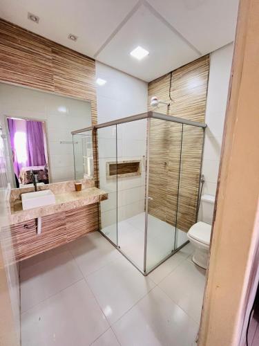 a bathroom with a glass shower and a toilet at Apartamento panorâmico com 2 suítes 1 quarto in Petrolina