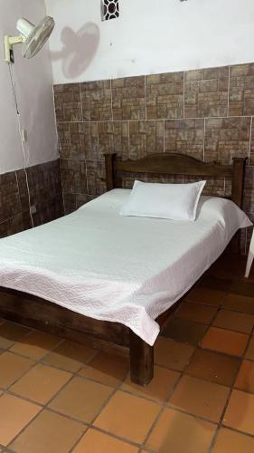 a bed in a room with a white bedsheet at Hotel Campestre Villa Lucila in San Gil