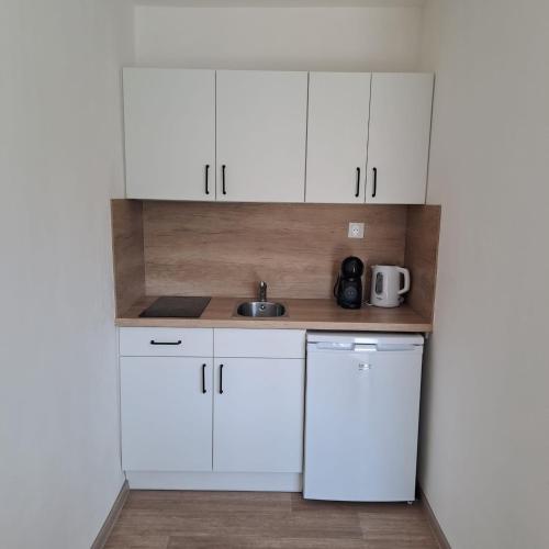 a kitchen with white cabinets and a sink at Valen apartmány Valtice in Valtice