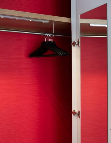 a closet with a red curtain and a hanger at Roosevelt Stadthaus in Vienna